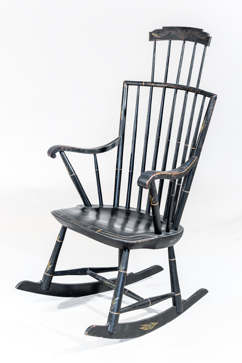 A rod backed windsor rocker with elongated step-down crest rail